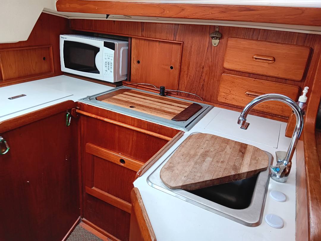 Galley with fitted teak cutting boards over the stove and sink