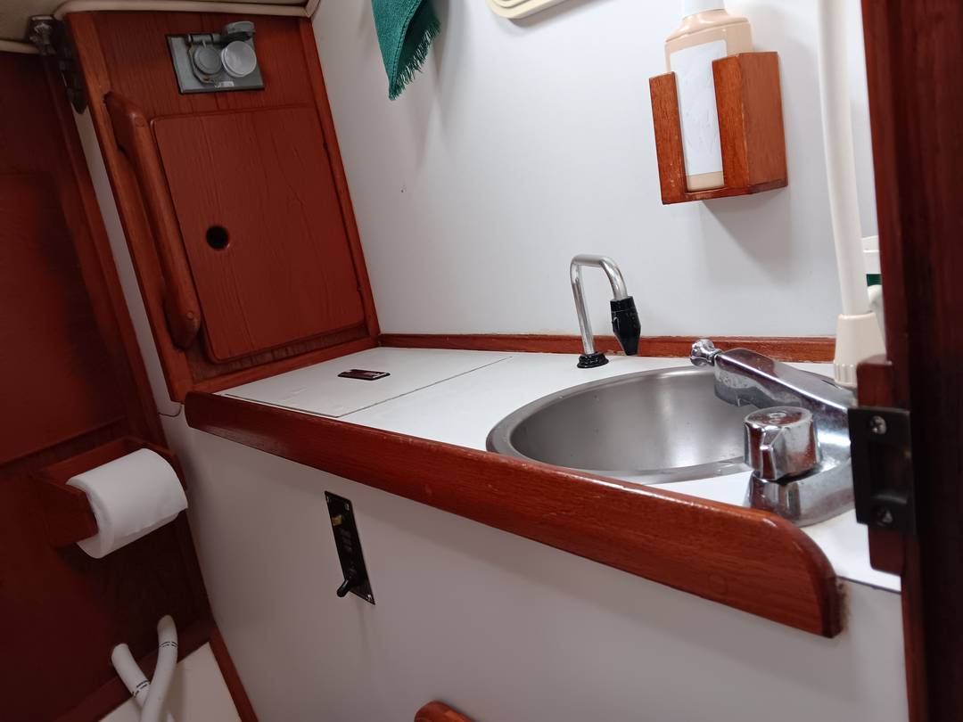 Vanity with stainless sink and teak trim in the head